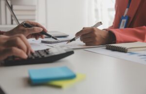 Asesoría plan general contable en Valencia revisando documentos financieros y cálculos fiscales en oficina