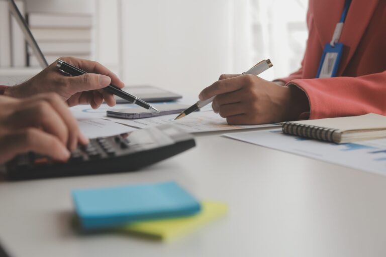 Asesoría plan general contable en Valencia revisando documentos financieros y cálculos fiscales en oficina